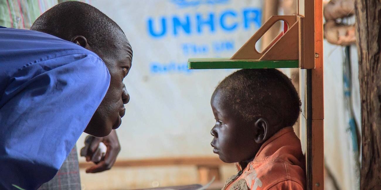 A-doctor-checks-the-height-of-a-refugee-child-in-one-of-the-temporary-UNHCR-medical-centres-in-bidibidi-refugee-camp-photographer-in-kenya