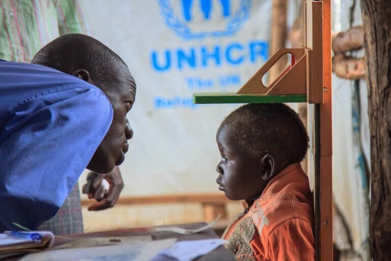 A-doctor-checks-the-height-of-a-refugee-child-in-one-of-the-temporary-UNHCR-medical-centres-in-bidibidi-refugee-camp-photographer-in-kenya