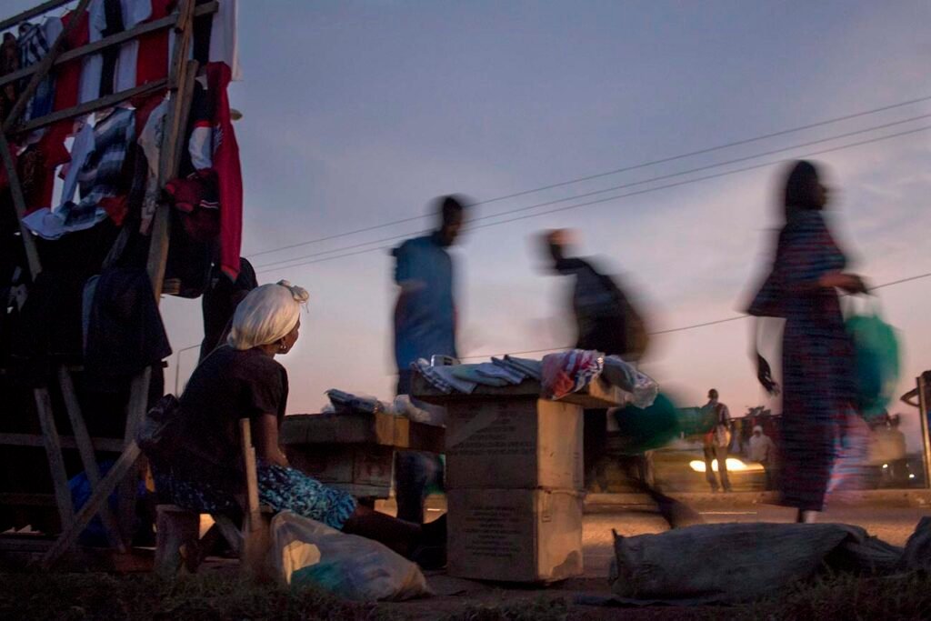 A-lady-sits-by-the-roaside-in-kampala-selling-small-products-to-passers-by-in-kalerwe-market