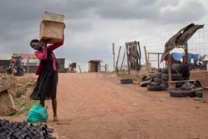 A-lady-walks-to-the-street-to-set-up-her-stall-on-a-cloudy-day-in-kalerweKampalaUganda
