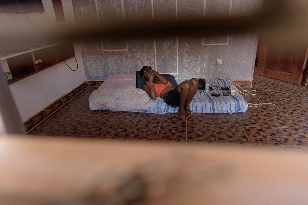 A-lesbian-scrolls-through-her-phone-alonein-her-home-as-she-fears-to-move-our-amidst-violence-towards-the-LGBTQ-community-in-kampalaUganda