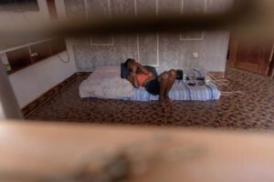 A-lesbian-scrolls-through-her-phone-alonein-her-home-as-she-fears-to-move-our-amidst-violence-towards-the-LGBTQ-community-in-kampalaUganda