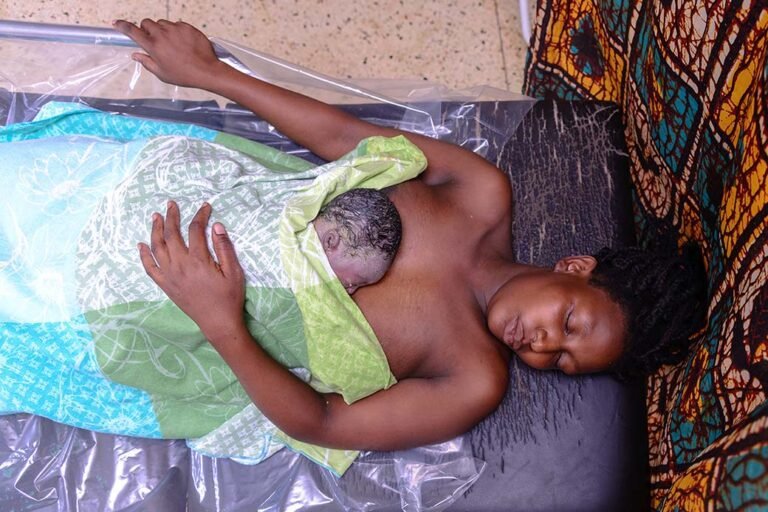 A-mother-has-a-skin-to-skin-moment-with-her-newborn-baby-in-mayuge-hospital-Jinja-uganda-despie-the-lack-of-proper-maternal-health-services-in-uganda-photographer-in-kenya