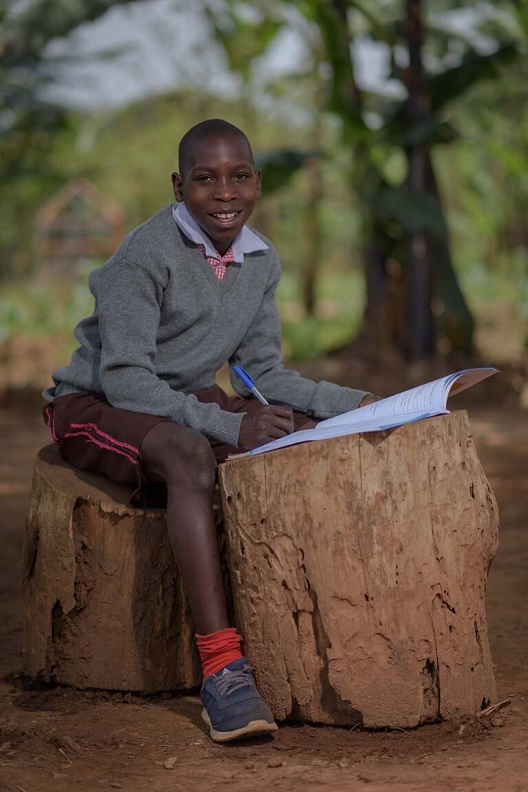 A-students-reads-his-books-under-a-tree-shade-in-a-remote-village-photographer-in-kenya