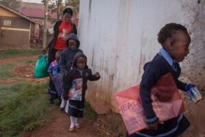 Annet-arrives-at-school-in-the-mornign-with-some-children-whom-she-escorts-to-school-from-the-neighbourhood-in-KampalaUganda
