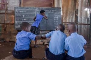 Annet-teaches-a-group-of-pupils-inside-an-iron-sheet-church-in-kalerweUganda